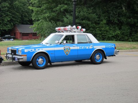 1991 Ford LTD Crown Victoria - Driver-side profile of a blue-and-white Dodge Diplomat sedan in NYPD livery, lettered 'POLICE' and 'HWY 3' with unit 2840 on the rear quart…