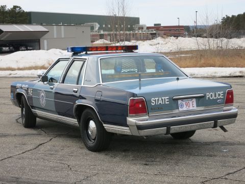 1991 Ford LTD Crown Victoria - Rear three-quarter view of a two-tone light-and-dark blue Ford LTD Crown Victoria in Massachusetts State Police livery, marked 'STATE POLIC…