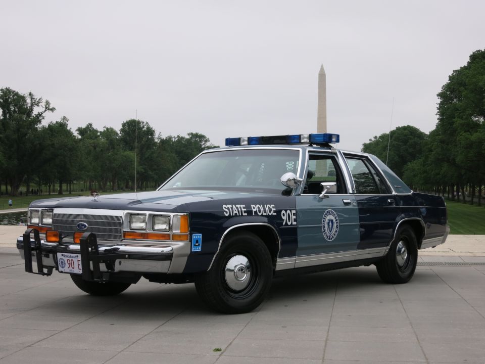 Dark blue and grey 1991 Ford Crown Victoria police car, front quarter view, with light bar and push bumper