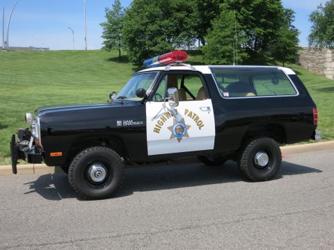 1991 Ford LTD Crown Victoria - Driver-side profile of a black-and-white Dodge Ram Charger two-door 4x4 SUV done as a California Highway Patrol unit, with gold 'HIGHWAY PA…