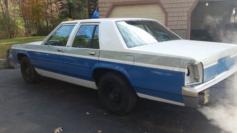 1991 Ford LTD Crown Victoria - Rear view of a 1991 Ford Crown Victoria showing smoke from the exhaust pipe.