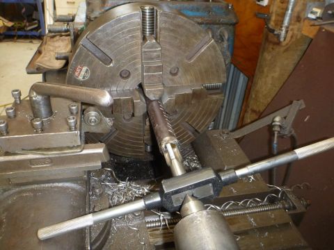 1964 Mercury Monterey - A metal rod is being threaded on a lathe using a tap wrench and cutting fluid.