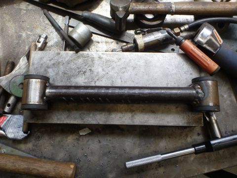1964 Mercury Monterey - A metal suspension control arm with rubber bushings is shown on a workbench with various tools.