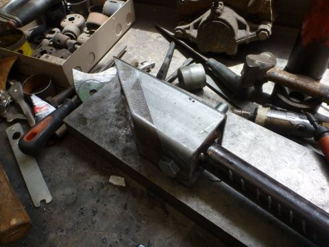 1964 Mercury Monterey - A fabricated suspension component rests on a workbench alongside tools and other parts.
