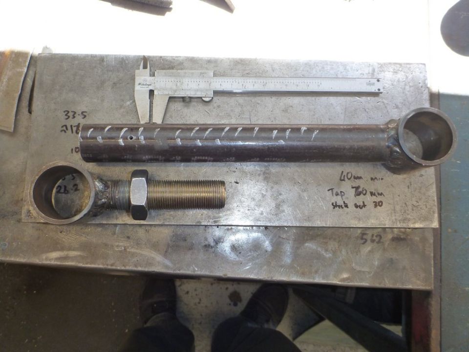Metal rod with threaded bolt and caliper for measurement. Handwritten notes indicate dimensions