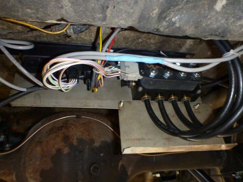 1964 Mercury Monterey - Close-up view of air suspension components, including a manifold, wiring, and hoses, mounted beneath a vehicle.