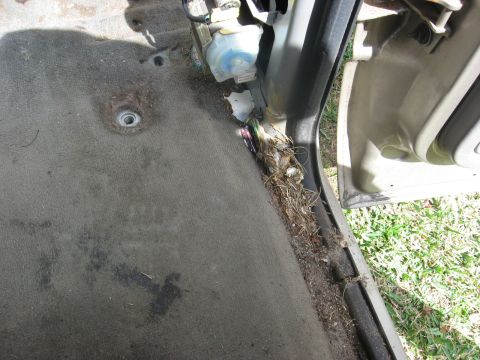 1994 Ford Bronco - Debris and wiring are visible along the interior door jamb of a vehicle.
