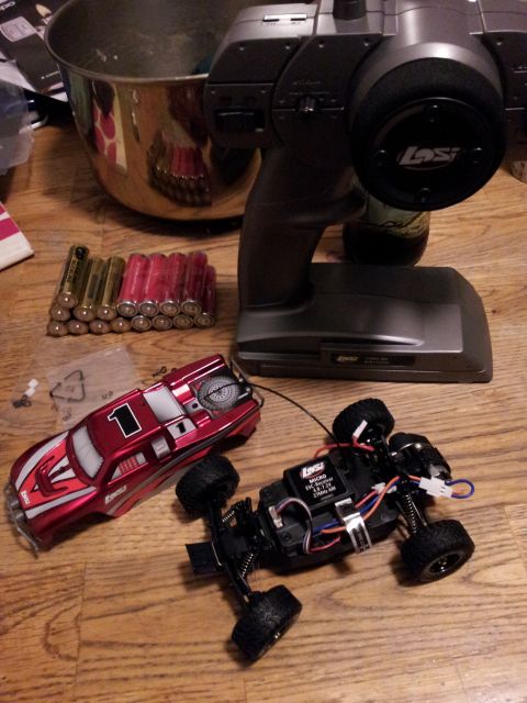 1995 Ford Bronco - Remote control car components including the body, chassis, and controller are laid out with batteries.