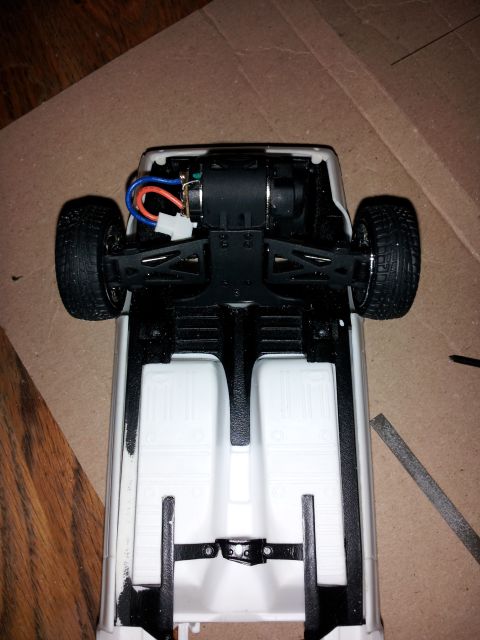 1995 Ford Bronco - The underside of a model car chassis reveals its motor and suspension components.