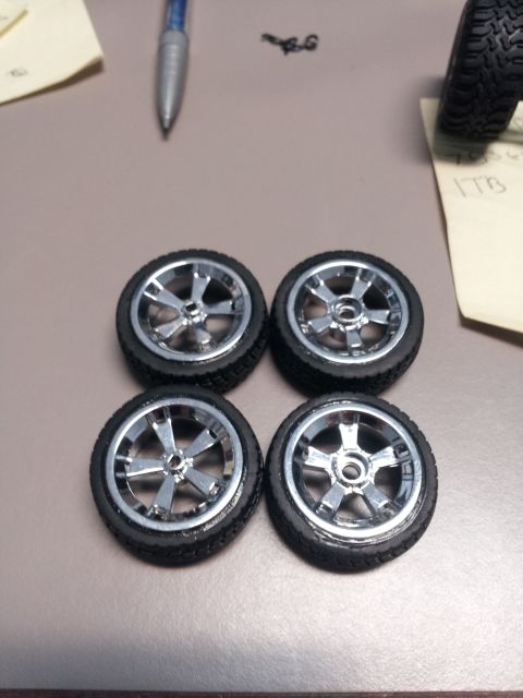 1995 Ford Bronco - Model car wheels and tires are laid out on a table, possibly for a project.