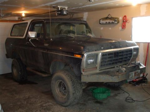 1979 Ford Bronco - This Ford Bronco is parked in a garage, possibly undergoing maintenance, with a green oil drain pan visible underneath.