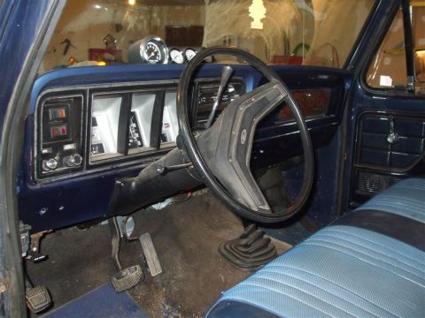 1979 Ford Bronco - The interior of a 1979 Ford Bronco features blue upholstery and a dashboard with aftermarket gauges.