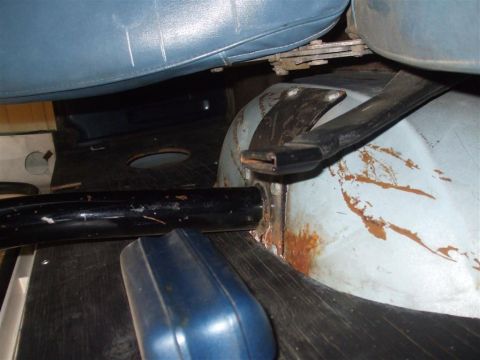 1979 Ford Bronco - The interior floor of the vehicle shows signs of rust and wear around the seat mounting hardware.
