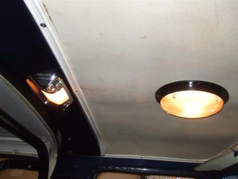 1979 Ford Bronco - Interior view of a vehicle's ceiling, showing two illuminated lights and dark trim.