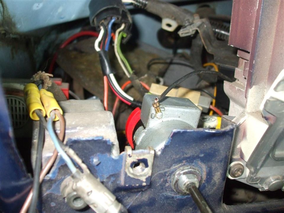 Close-up of vehicle wiring harness with yellow connectors and metal components
