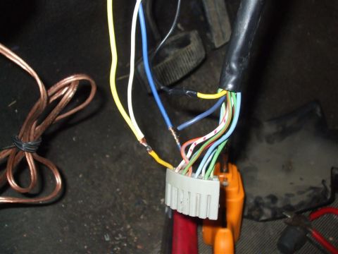 1979 Ford Bronco - A close-up view of a vehicle's electrical wiring harness, showing various colored wires and a connector.
