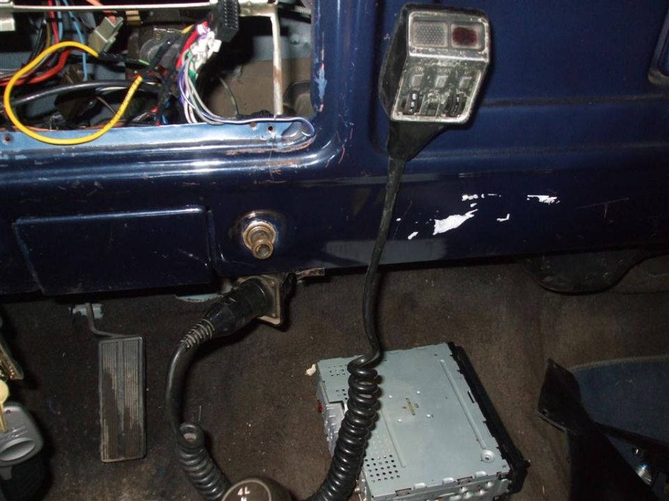 CB radio microphone and aftermarket stereo installed in a dark blue vehicle interior