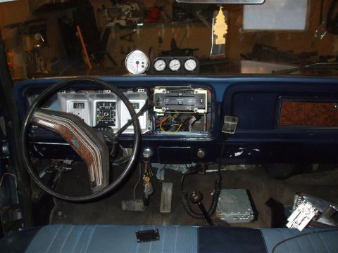 1979 Ford Bronco - The interior of a 1979 Ford Bronco shows a dashboard with gauges and an open radio slot.