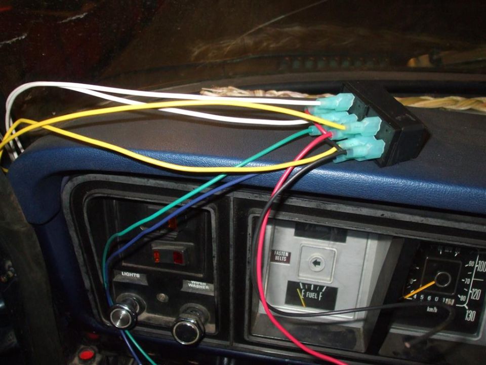 Dashboard wiring with aftermarket connectors and gauges visible. Fuel gauge shows F