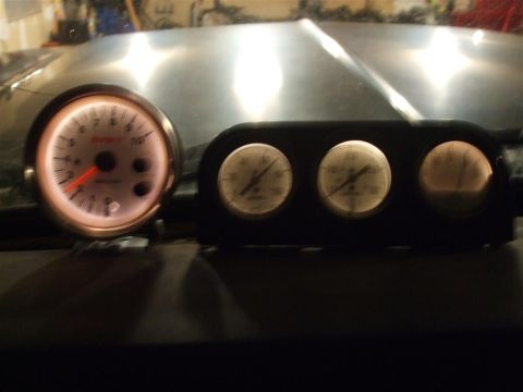 1979 Ford Bronco - Close-up of illuminated vehicle gauges, including a tachometer and other readouts.