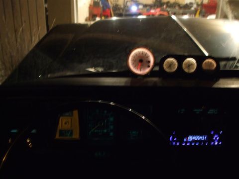 1979 Ford Bronco - Aftermarket gauges and a digital radio are visible on the dashboard of a car.