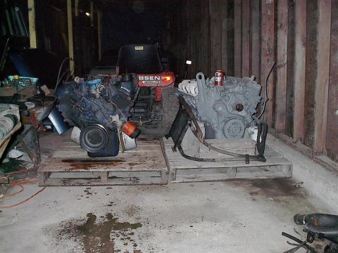 1979 Ford Bronco - Two engines are stored on pallets in a garage, with a red tractor visible in the background.