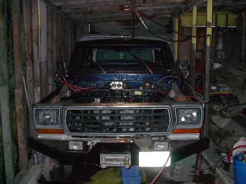 1979 Ford Bronco - This 1979 Ford Bronco is in a garage with its hood open, revealing the engine for maintenance.