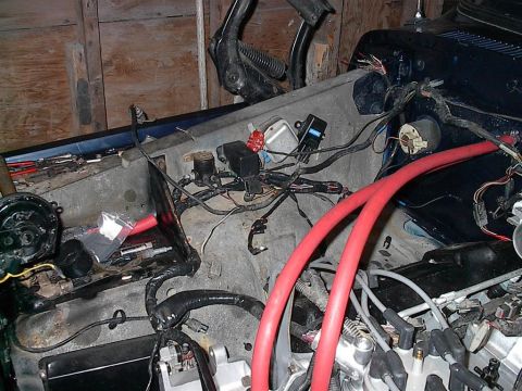 1979 Ford Bronco - The engine bay of a vehicle displays a tangled mess of wires and hoses, suggesting ongoing maintenance or repair.