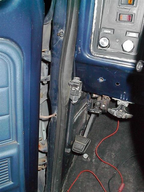 1979 Ford Bronco - View of the driver's side door jamb and lower dashboard area, with exposed wiring visible.