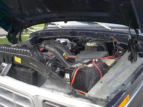1979 Ford Bronco - The engine bay of a 1979 Ford Bronco, showing the battery and various engine components.