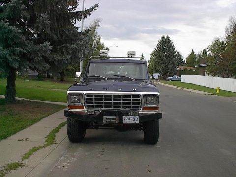 1979 Ford Bronco - Front view of a 1979 Ford Bronco parked on a residential street, equipped with a winch and custom bumper.