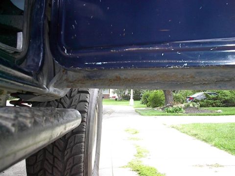 1979 Ford Bronco - Close-up of vehicle undercarriage, with a second vehicle visible in the distance.
