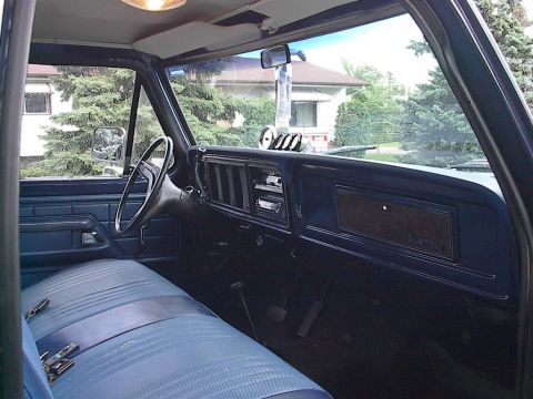 1979 Ford Bronco - Interior view of a 1979 Ford Bronco, its blue bench seat and dashboard details.