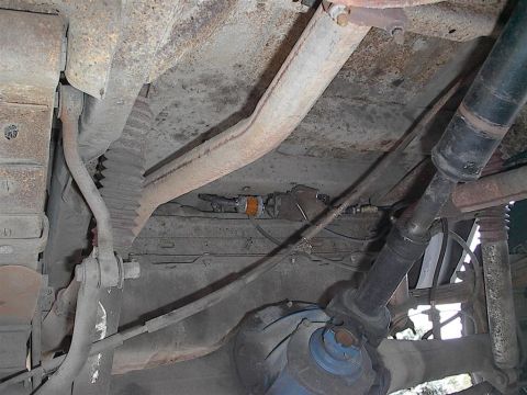 1979 Ford Bronco - Underside view of a vehicle's chassis, showing exhaust pipes, driveshaft, and suspension parts.