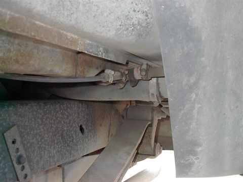 1979 Ford Bronco - Close-up view of the underbody of a vehicle, revealing suspension parts and fuel lines.