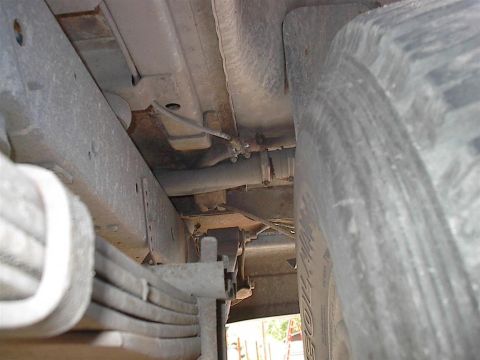1979 Ford Bronco - A close-up view of the undercarriage of a vehicle reveals its suspension and tire, with a watermark indicating the source.