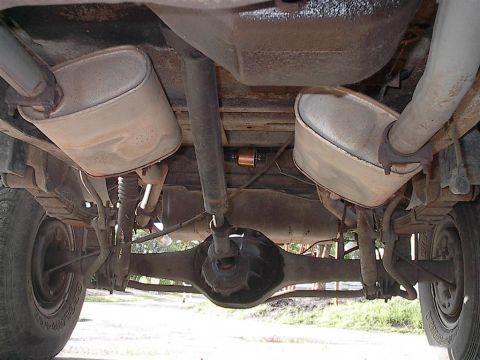 1979 Ford Bronco - This photo shows the rear axle, suspension, and dual exhaust system of a vehicle, including a visible fuel filter.