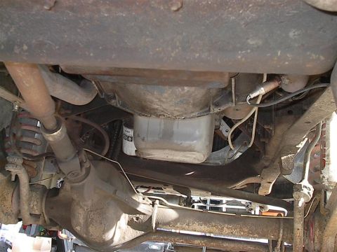 1979 Ford Bronco - The underside of a vehicle reveals its mechanical components, including the drivetrain and suspension.