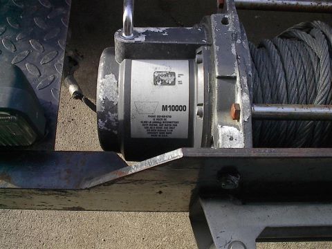 1979 Ford Bronco - Close-up of a winch labeled M10000, a steel cable and visible text on its housing.