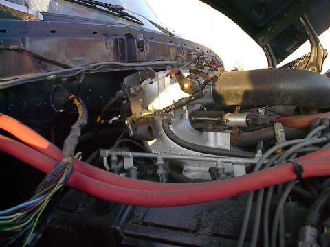 1979 Ford Bronco - Close-up view of a vehicle's engine bay, focusing on the throttle body and intake system.