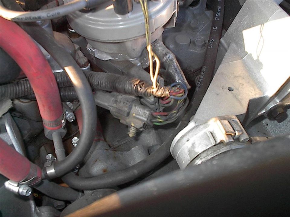 Close-up of frayed engine wiring harness with exposed wires and connectors