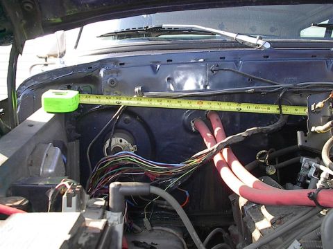 1979 Ford Bronco - A measuring tape is used to assess dimensions within the engine bay of a vehicle.