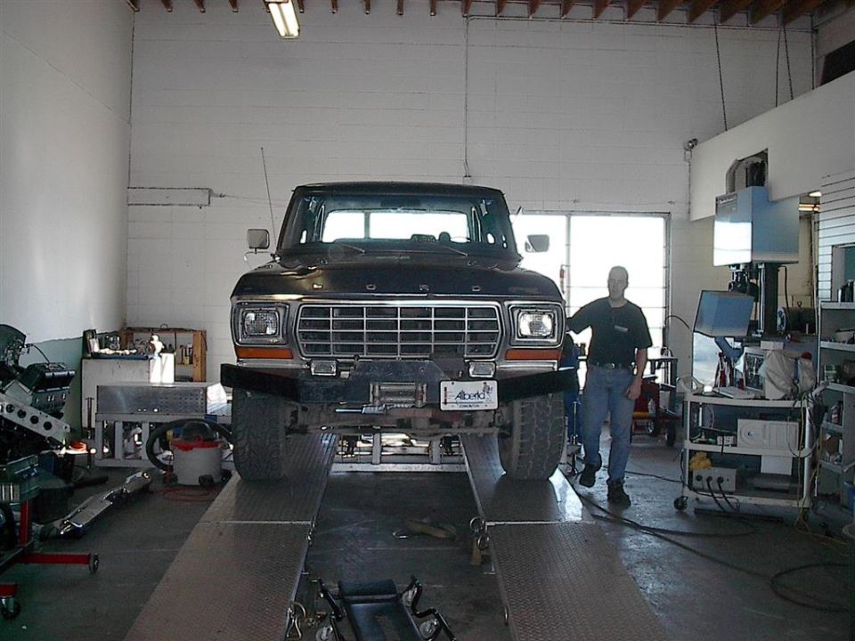 1979 Ford Bronco on a lift in a garage, front view. Man stands beside it
