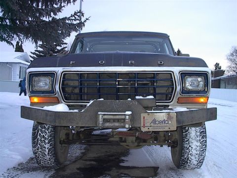 1979 Ford Bronco - This Ford truck, likely from the late 1970s, is equipped with a heavy-duty winch bumper and winter tires.