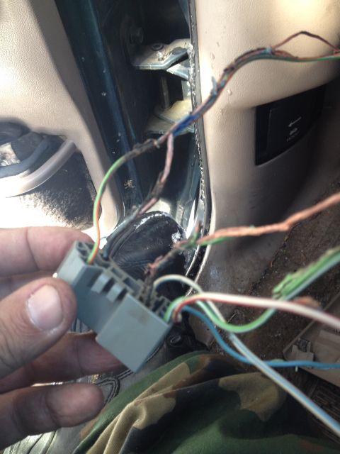 1993 Ford Bronco - Damaged wiring harness connector with frayed wires visible inside a vehicle.