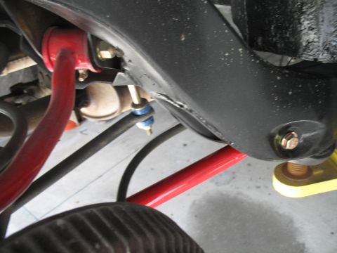 1972 Ford Ranchero - Close-up view of vehicle suspension components, including a red sway bar and black control arms.