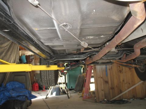1972 Ford Ranchero - The underside of a vehicle is shown, lifted for inspection or repair, revealing the frame and exhaust components.