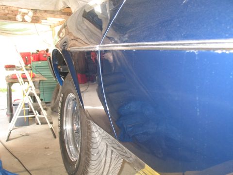 1972 Ford Ranchero - The side of a blue vehicle is shown, with a chrome trim line running along the body panel.