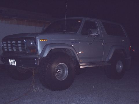 1996 Ford Bronco - This 1980 Ford Bronco is equipped with oversized tires and appears to be parked outdoors at night.