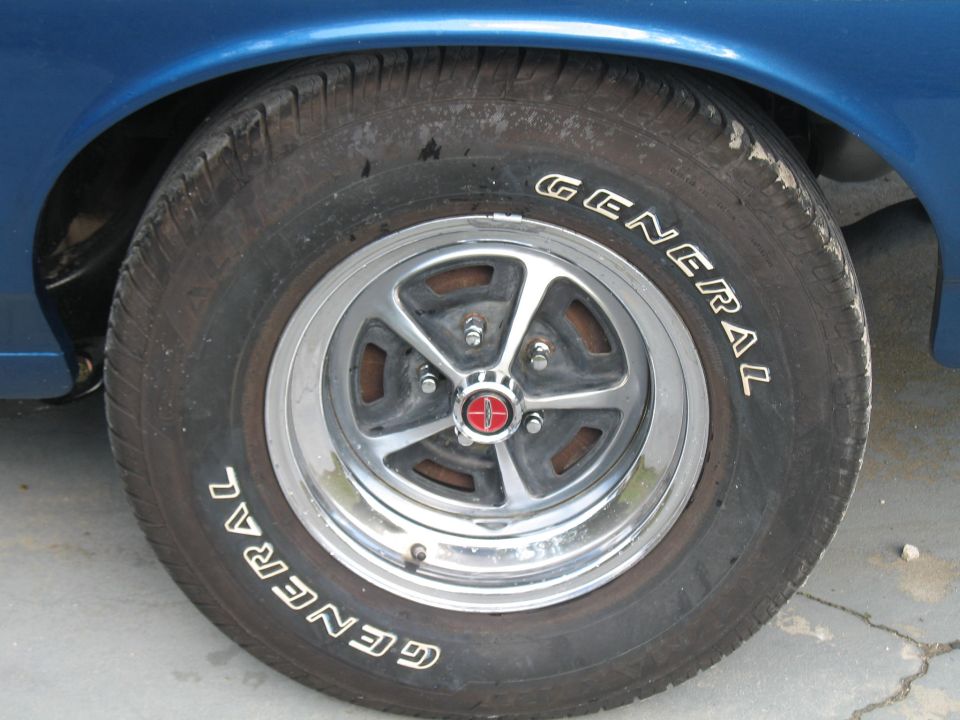 Close-up of a General tire on a chrome wheel with a red center cap